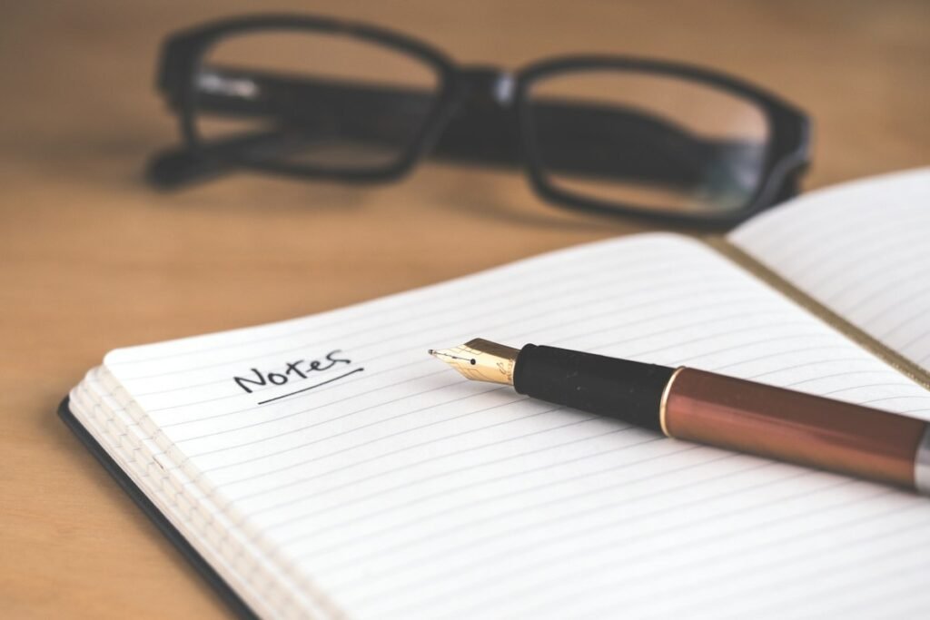 Transcription jobs online - notebook and glasses on a desk